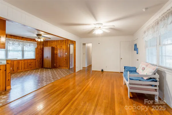 a kitchen with stainless steel appliances granite countertop a refrigerator a sink dishwasher a stove and a dining table with wooden floor