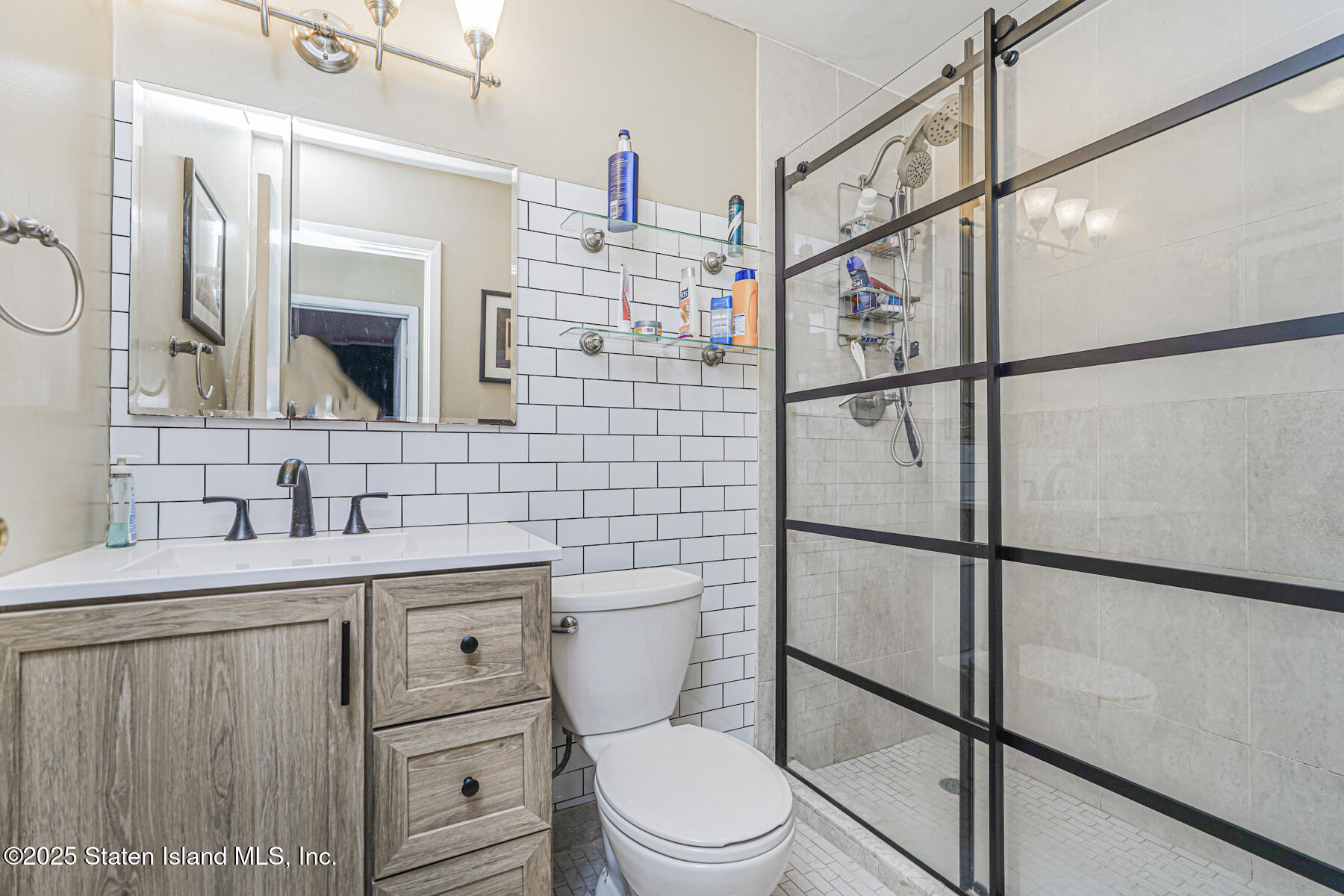 272 Timber Ridge Drive Staten Island, NY 10306 - Photo 12 of 26 a bathroom with a toilet sink vanity and mirror
