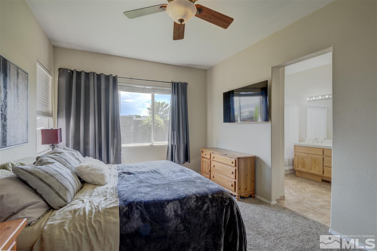 1660 Cattlemen Court Reno, NV 89521 - Photo 18 of 21 a bedroom with a bed a dresser and a chandelier