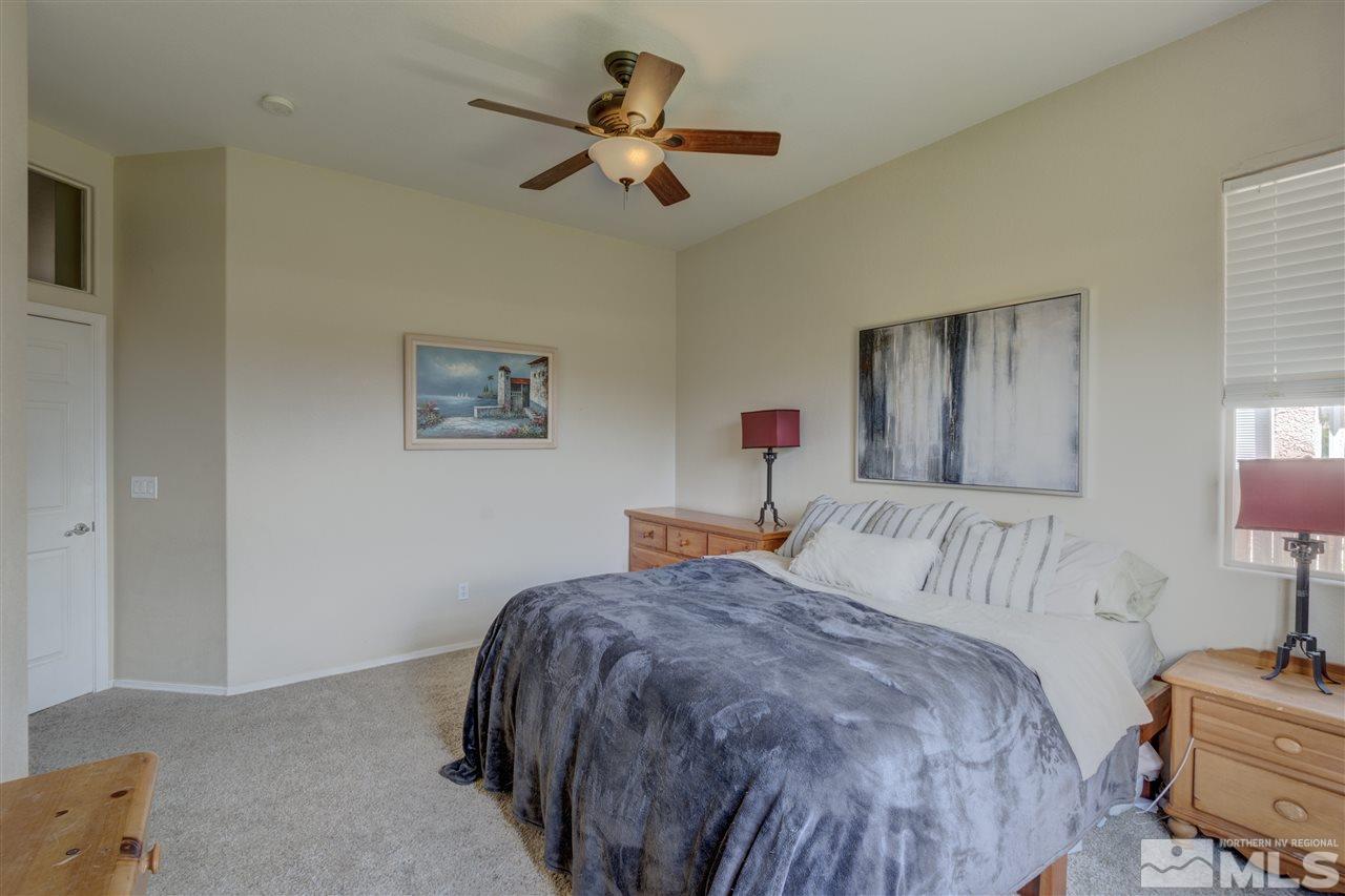 1660 Cattlemen Court Reno, NV 89521 - Photo 19 of 21 a bedroom with a bed a chandelier and a dresser