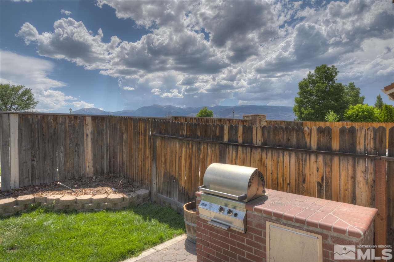 1660 Cattlemen Court Reno, NV 89521 - Photo 5 of 21 a view of backyard with barbeque grill and wooden fence