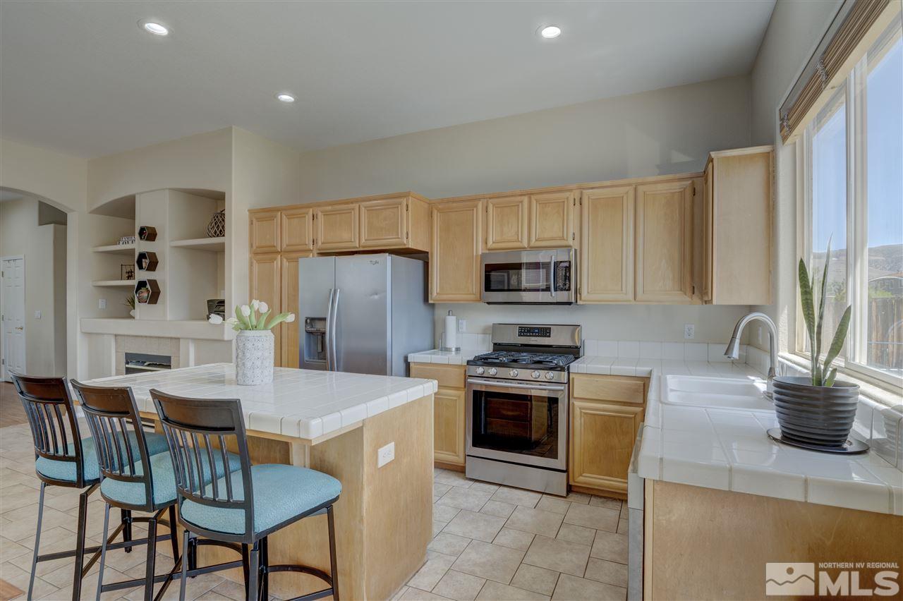 1660 Cattlemen Court Reno, NV 89521 - Photo 9 of 21 a kitchen with stainless steel appliances granite countertop a stove a sink a microwave and a refrigerator