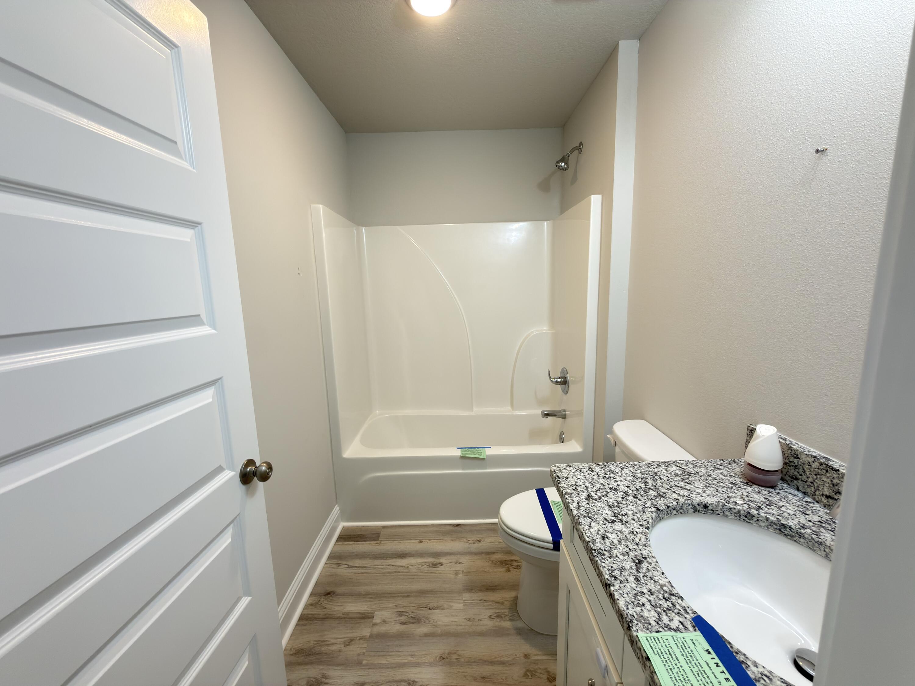 5281 Moore Loop Crestview, FL 32536 - Photo 13 of 28 a bathroom with a granite countertop sink and a bathtub