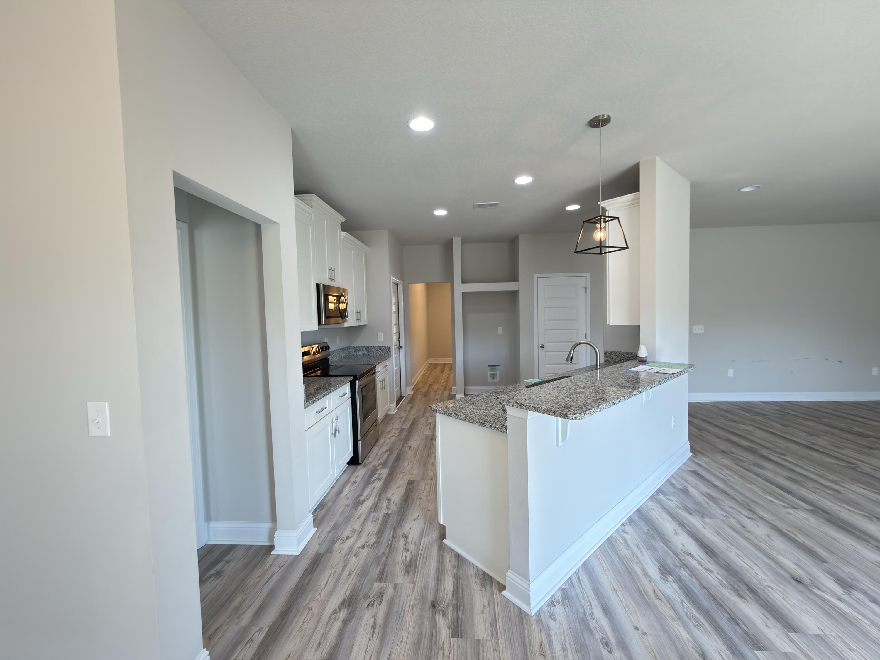 5281 Moore Loop Crestview, FL 32536 - Photo 6 of 28 a large kitchen with stainless steel appliances kitchen island a large counter top and a sink