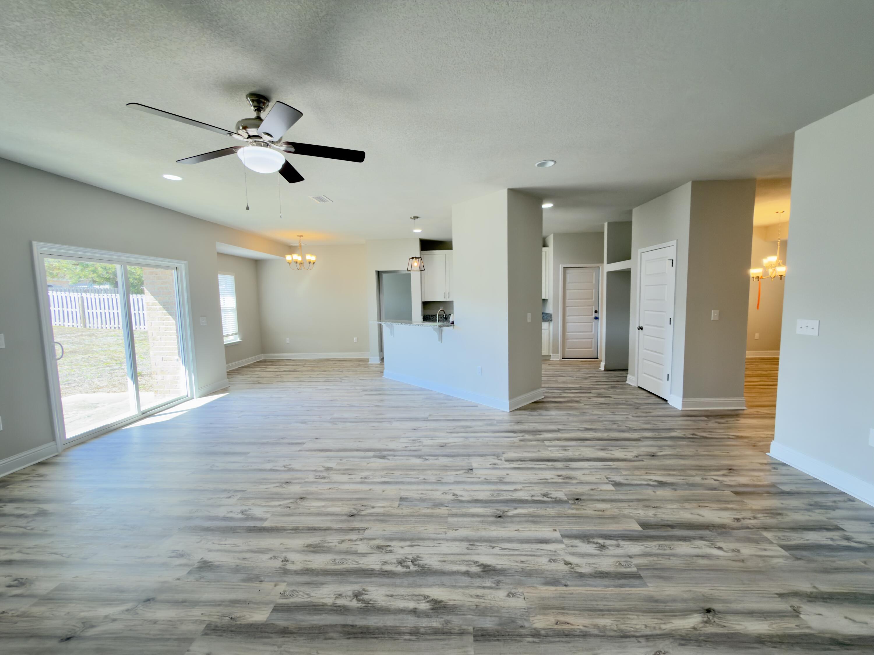 5281 Moore Loop Crestview, FL 32536 - Photo 8 of 28 a view of empty room with wooden floor and fan