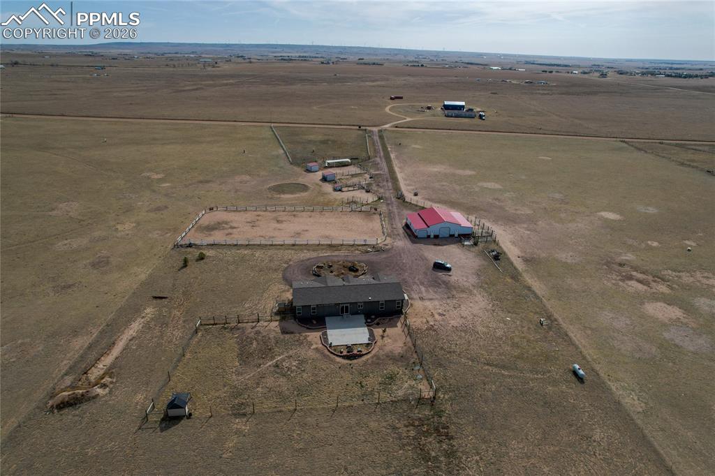7880 J D Johnson Road Peyton, CO 80831 - Photo 25 of 50 Expansive property featuring a main residence, two outbuildings, an outdoor arena, and multiple fenced areas