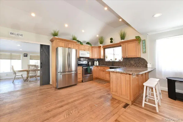a kitchen with stainless steel appliances granite countertop a refrigerator and a stove top oven