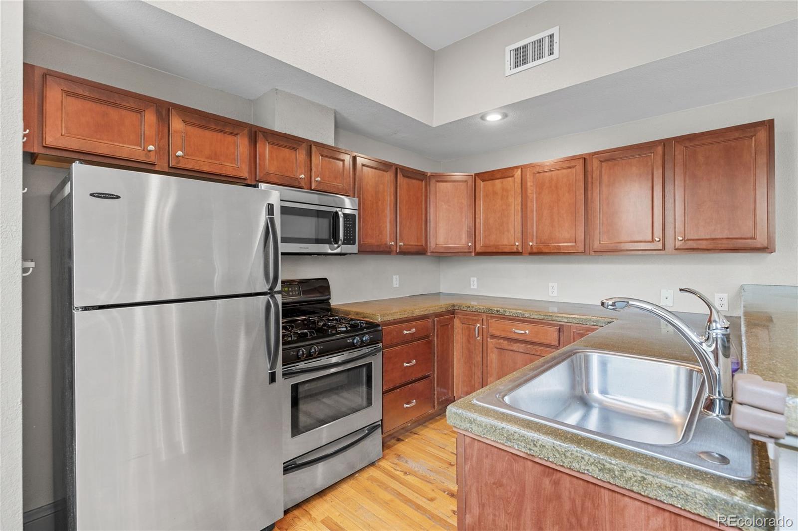 3211 Zuni Street, Unit 9 Denver, CO 80211 - Photo 13 of 36 a kitchen with stainless steel appliances a refrigerator sink and cabinets