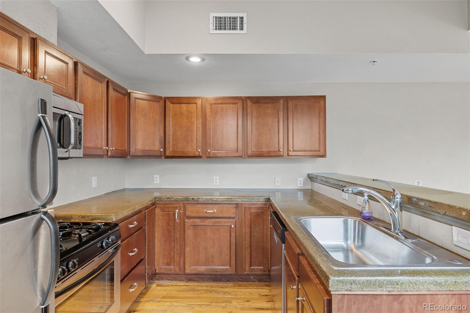 3211 Zuni Street, Unit 9 Denver, CO 80211 - Photo 14 of 36 a kitchen that has a sink cabinets counter space and stainless steel appliances
