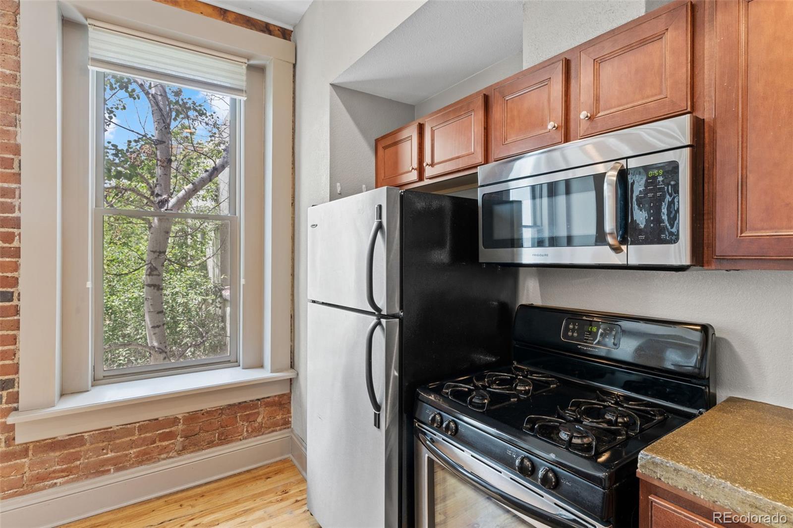 3211 Zuni Street, Unit 9 Denver, CO 80211 - Photo 18 of 36 a kitchen with stainless steel appliances granite countertop a stove a refrigerator and a microwave