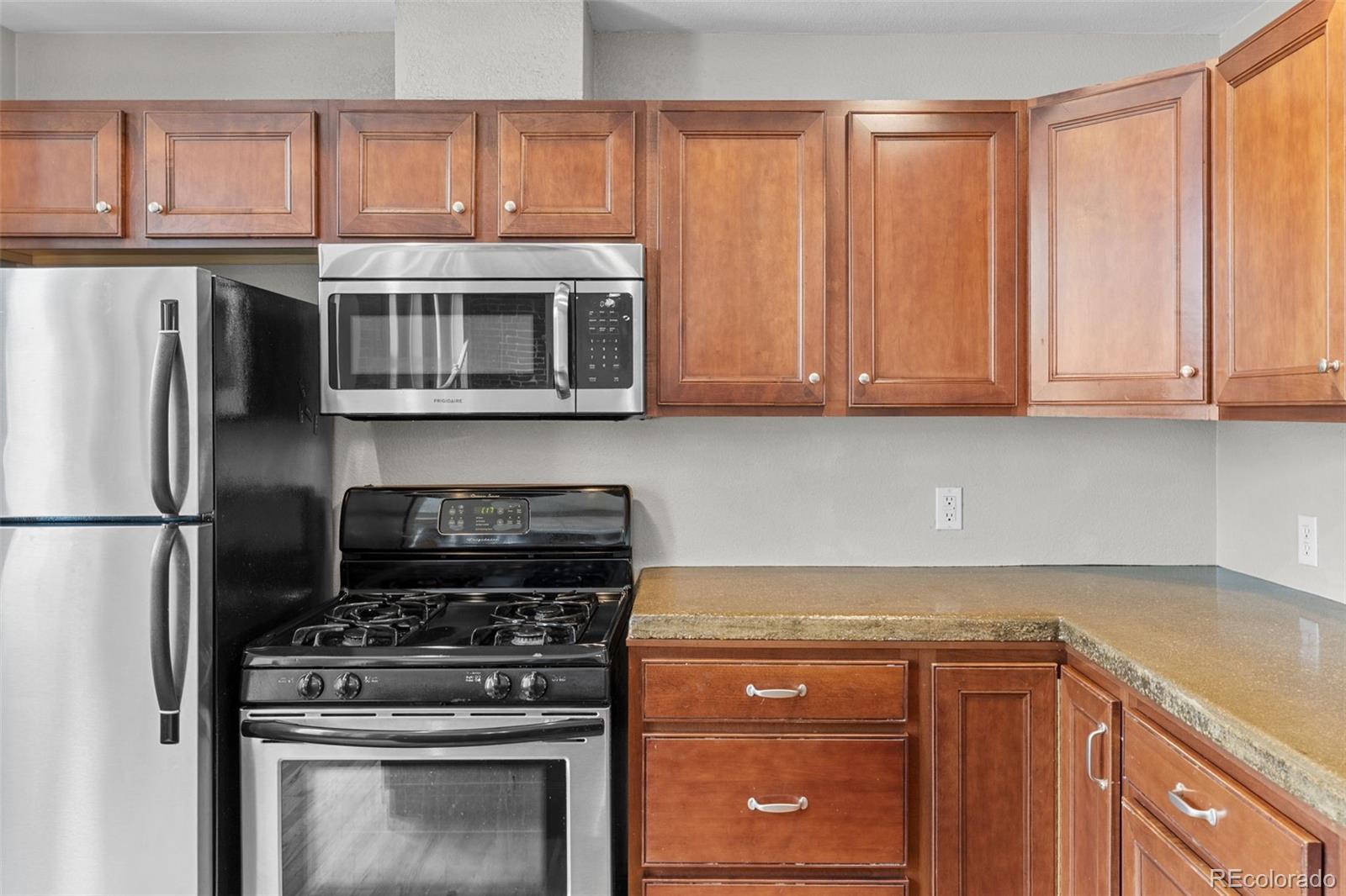 3211 Zuni Street, Unit 9 Denver, CO 80211 - Photo 19 of 36 a kitchen with granite countertop a stove top oven cabinetry and garage