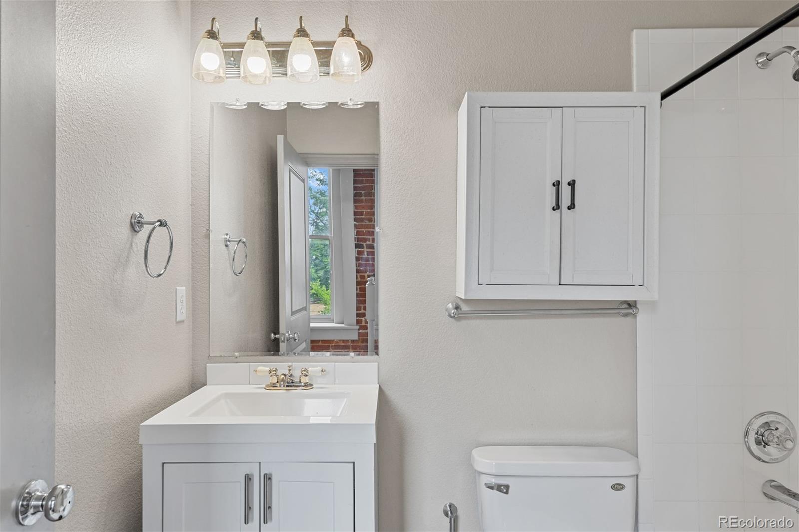 3211 Zuni Street, Unit 9 Denver, CO 80211 - Photo 20 of 36 a bathroom with a sink a toilet and a mirror