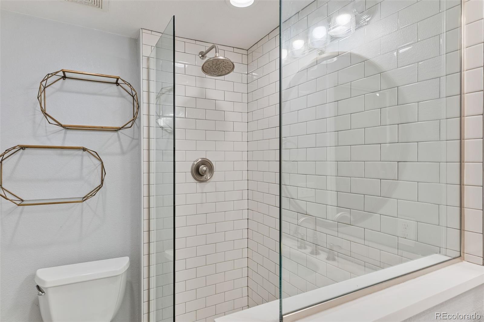 3211 Zuni Street, Unit 9 Denver, CO 80211 - Photo 34 of 36 a bathroom with a granite countertop toilet a sink and shower