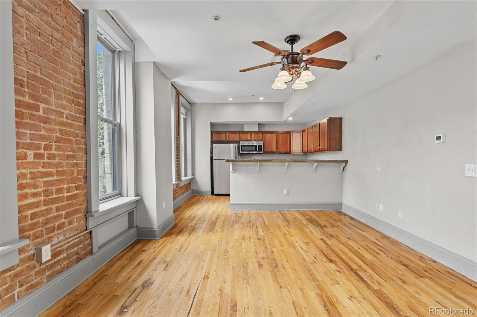 3211 Zuni Street, Unit 9 Denver, CO 80211 - Photo 8 of 36 a view of a livingroom with a ceiling fan and wooden floor