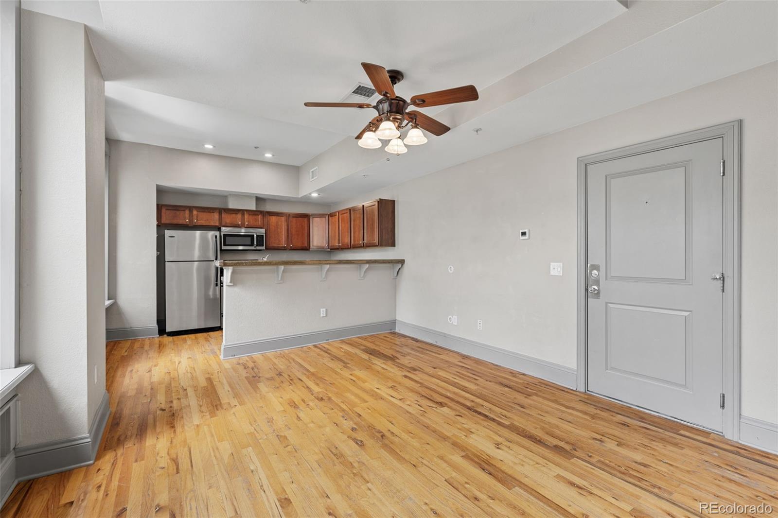 3211 Zuni Street, Unit 9 Denver, CO 80211 - Photo 9 of 36 a view of a kitchen with wooden floor and a ceiling fan