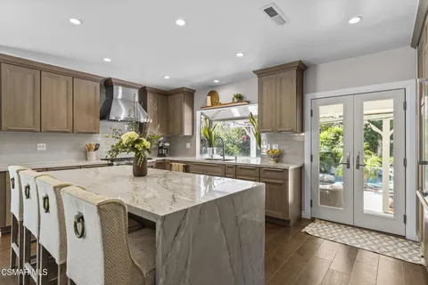 a kitchen with stainless steel appliances granite countertop sink stove and refrigerator