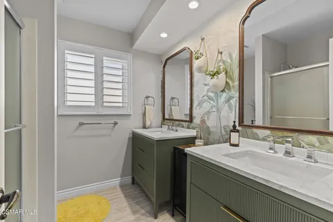 a bathroom with a granite countertop sink a mirror and a bathtub