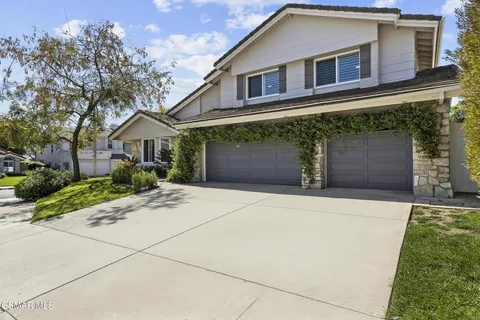 a front view of a house with a garden and yard