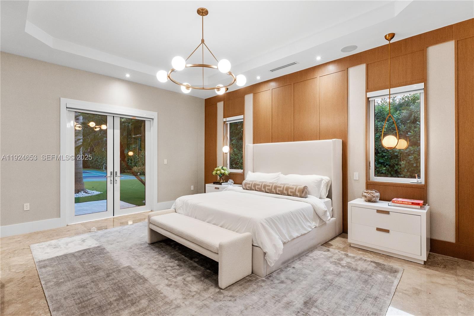 6080 Southwest 104th Street Pinecrest, FL 33156 - Photo 28 of 75 a spacious bedroom with a large bed and a chandelier