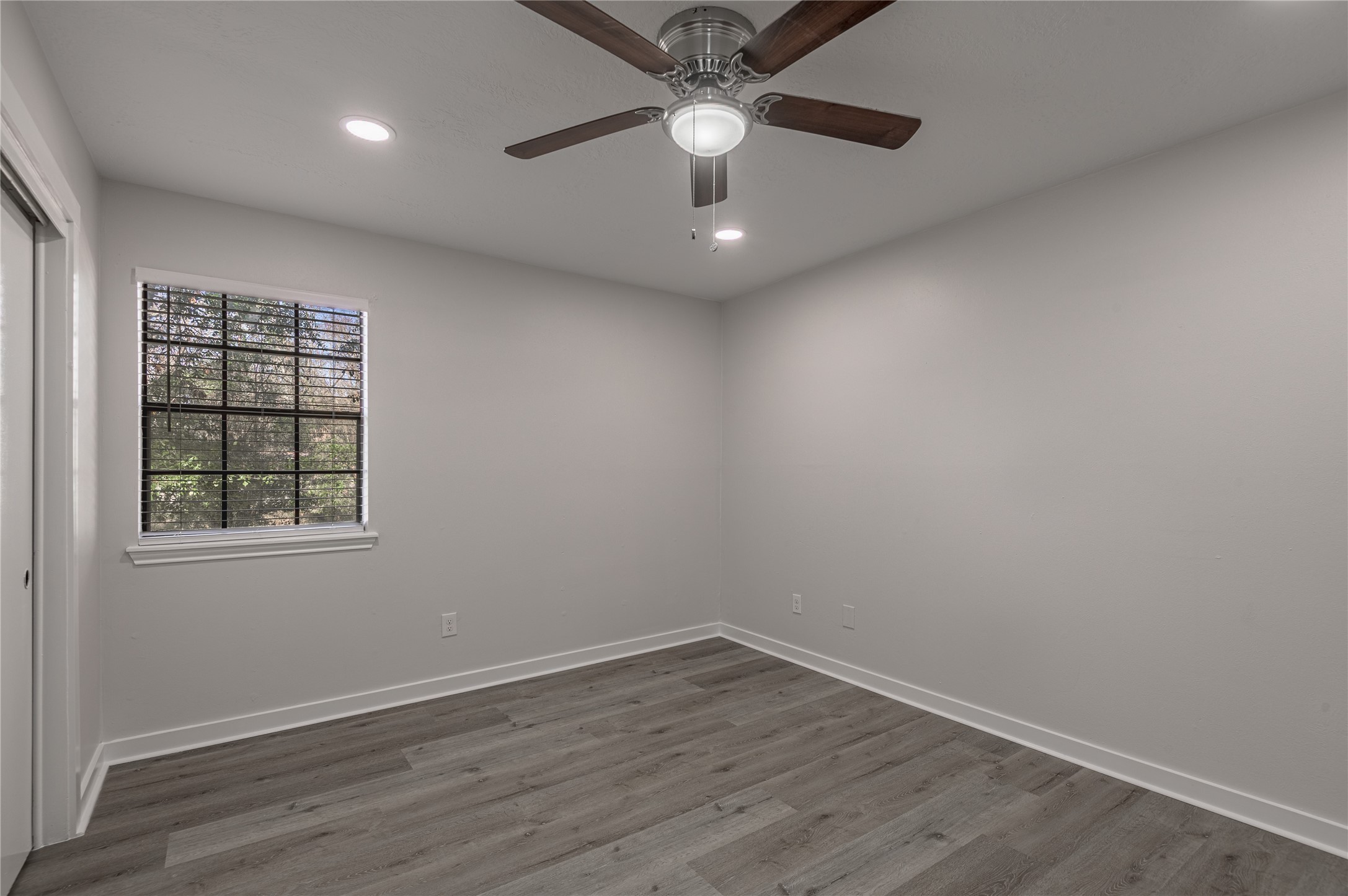 2401 Sycamore Avenue, Unit E2 Huntsville, TX 77340 - Photo 11 of 19 an empty room with wooden floor and windows