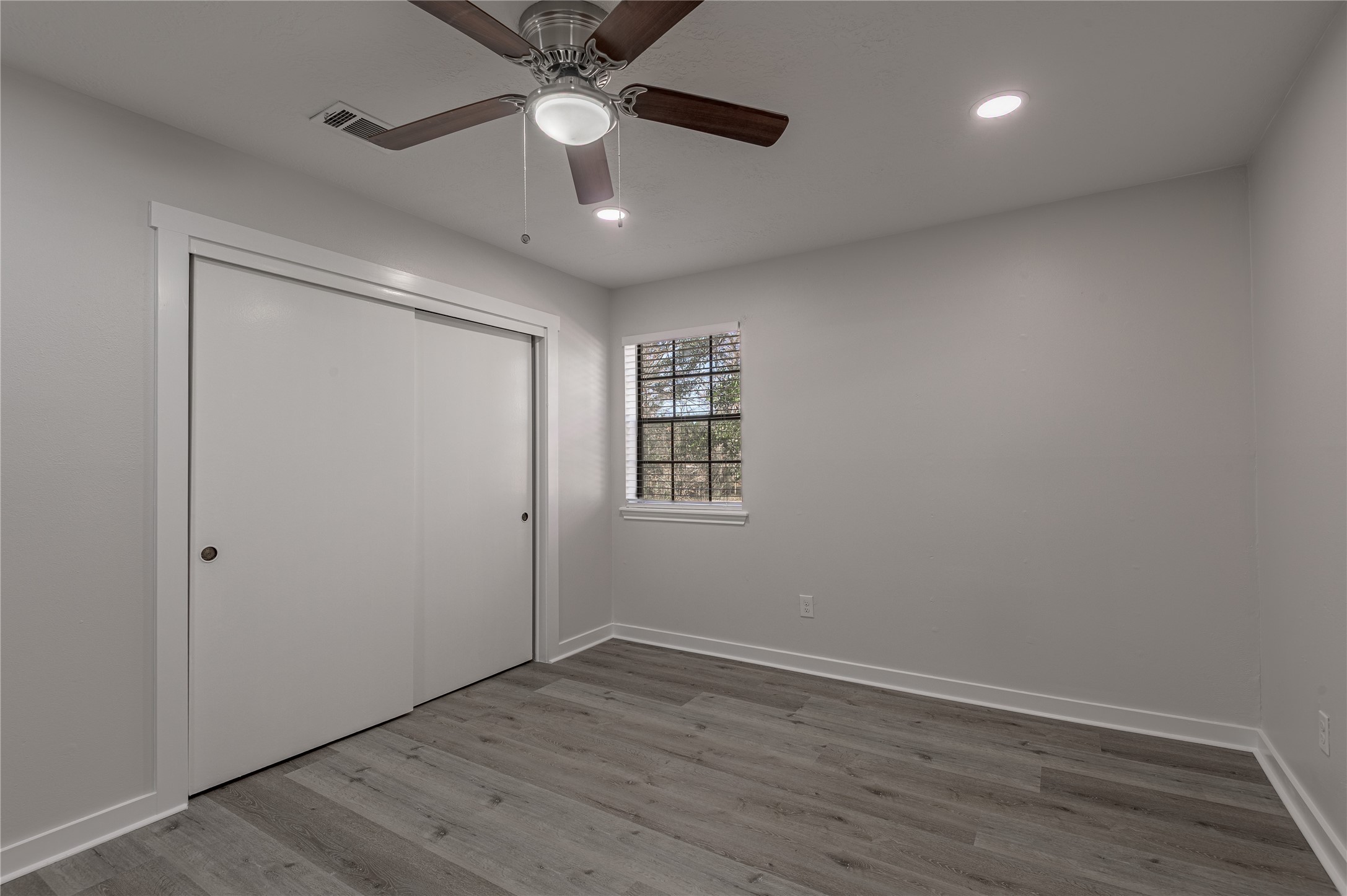 2401 Sycamore Avenue, Unit E2 Huntsville, TX 77340 - Photo 12 of 19 an empty room with wooden floor a ceiling fan and closet area