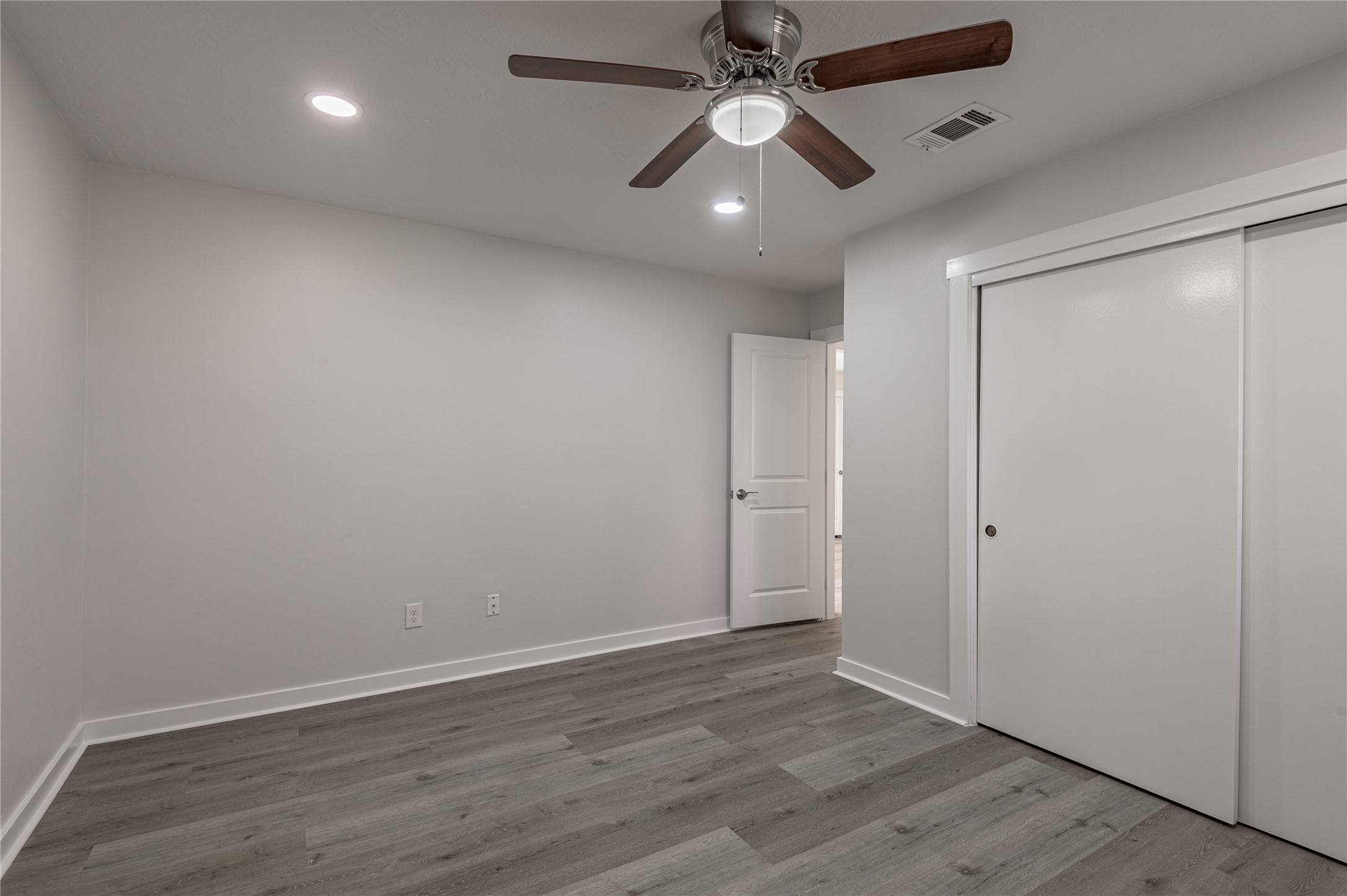 2401 Sycamore Avenue, Unit E2 Huntsville, TX 77340 - Photo 13 of 19 an empty room with wooden floor and windows
