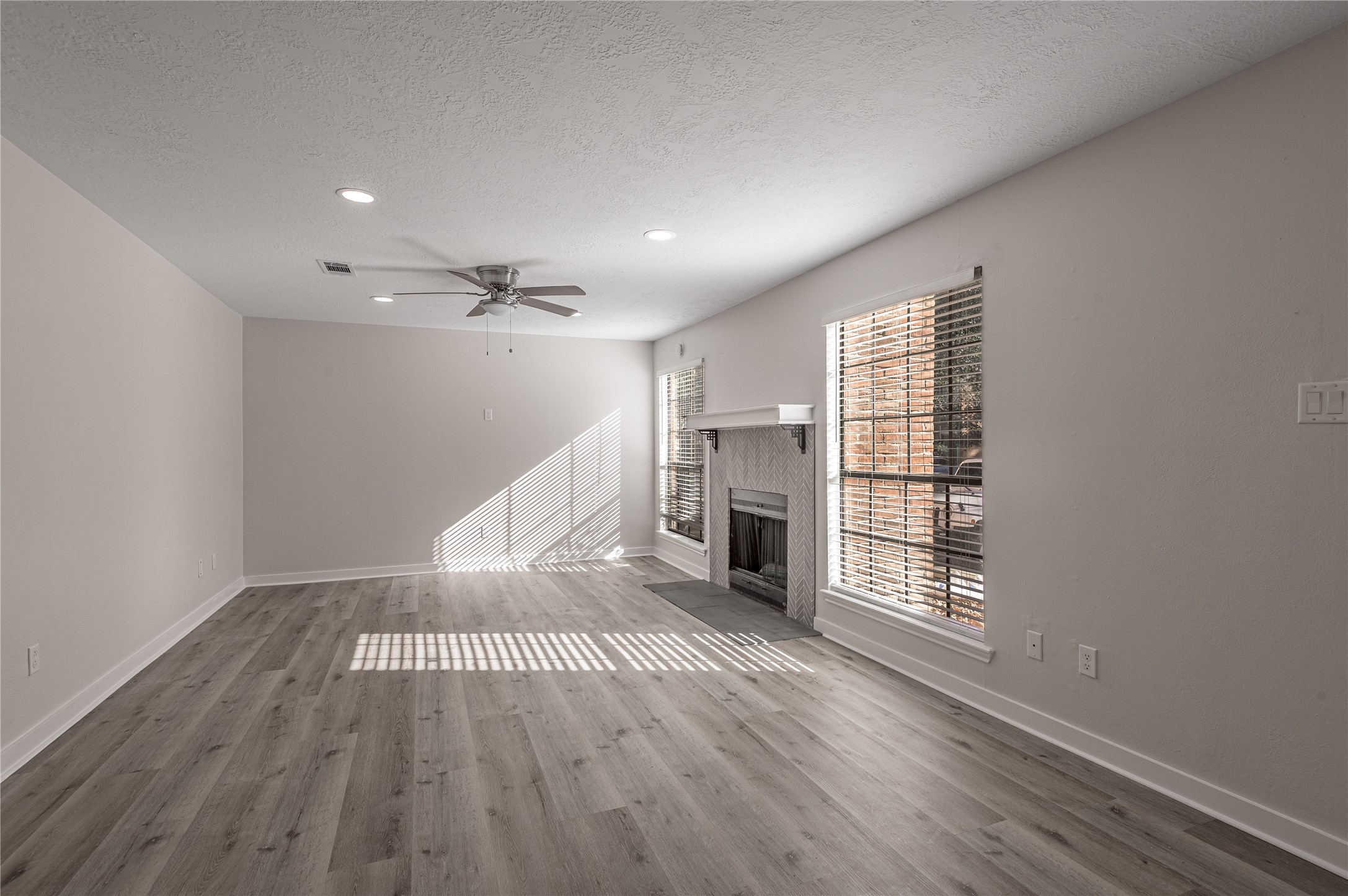 2401 Sycamore Avenue, Unit E2 Huntsville, TX 77340 - Photo 4 of 19 a view of an empty room with wooden floor fireplace and a window