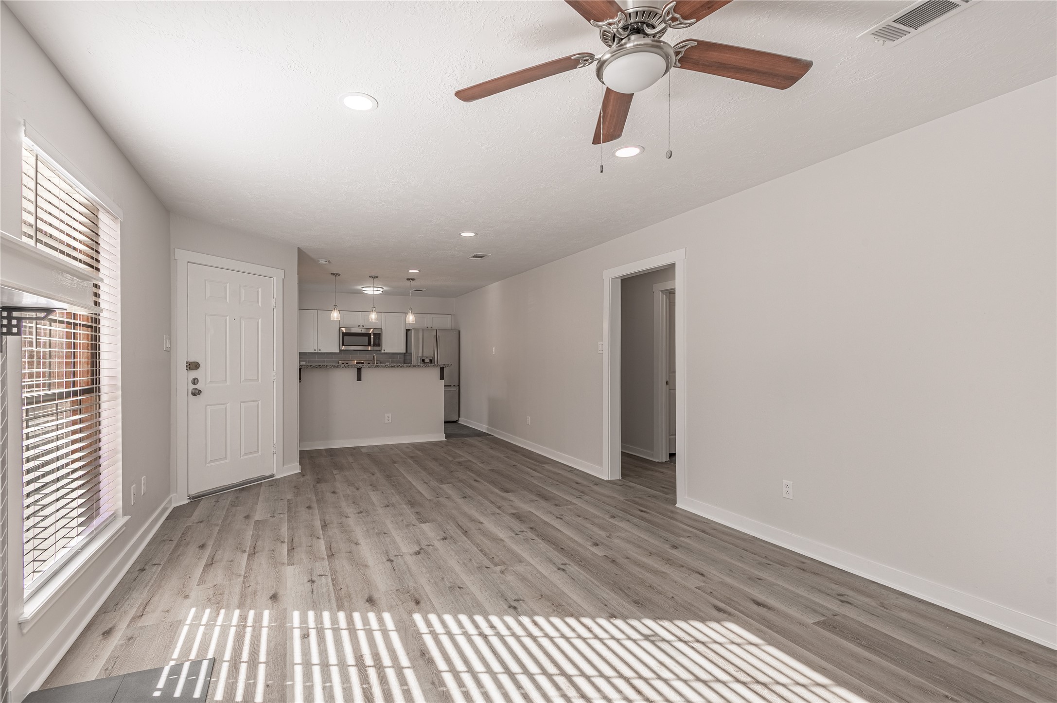 2401 Sycamore Avenue, Unit E2 Huntsville, TX 77340 - Photo 6 of 19 wooden floor in an empty room with a window