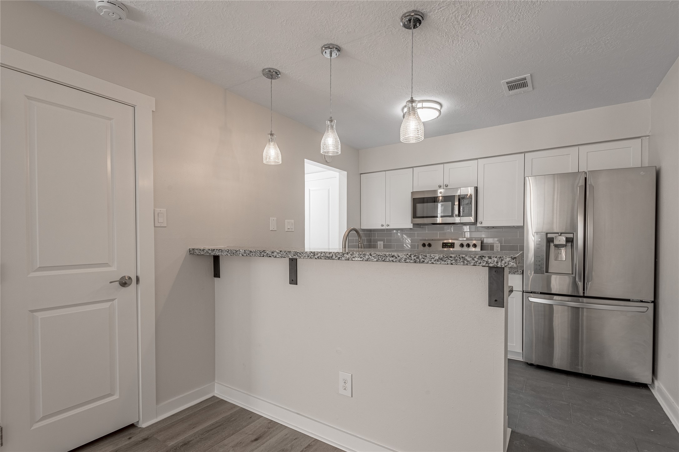 2401 Sycamore Avenue, Unit E2 Huntsville, TX 77340 - Photo 7 of 19 a kitchen with stainless steel appliances a refrigerator and microwave