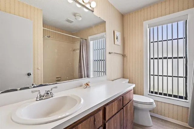 a view of a backyard with a floor to ceiling window and wooden fence
