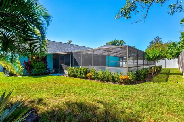 a view of a swimming pool with a yard and trees in the background