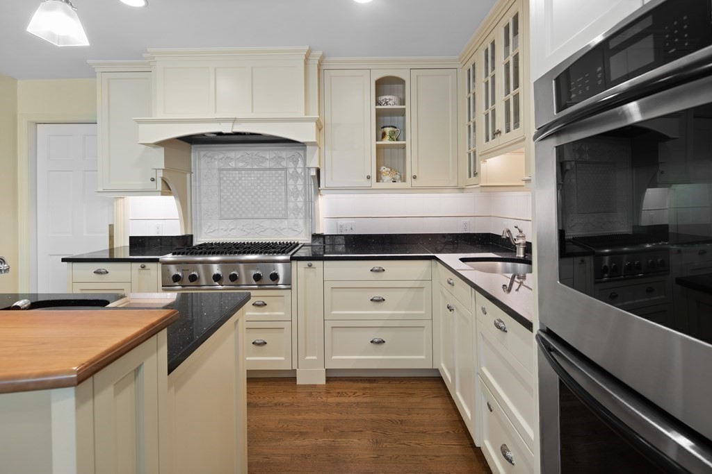 14 Wright Farm Concord, MA 01742 - Photo 6 of 34 a kitchen with a stove white cabinetry a sink and dishwasher
