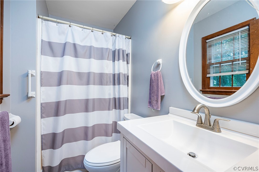 2806 Iverson Road Midlothian, VA 23112 - Photo 17 of 27 a bathroom with a sink a toilet a mirror and shower curtain