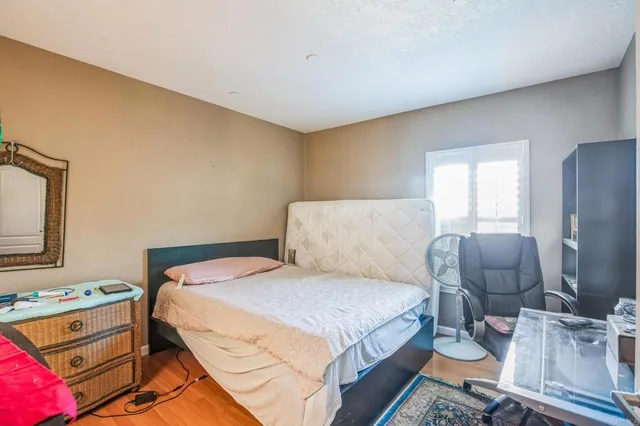 a bedroom with a bed and wooden floor