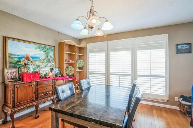 a view of a dining room with furniture a chandelier and wooden floor