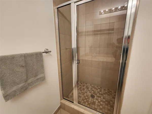 a bathroom with a glass shower door