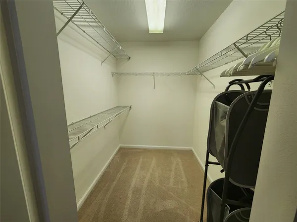 a view of walk in closet with clothes