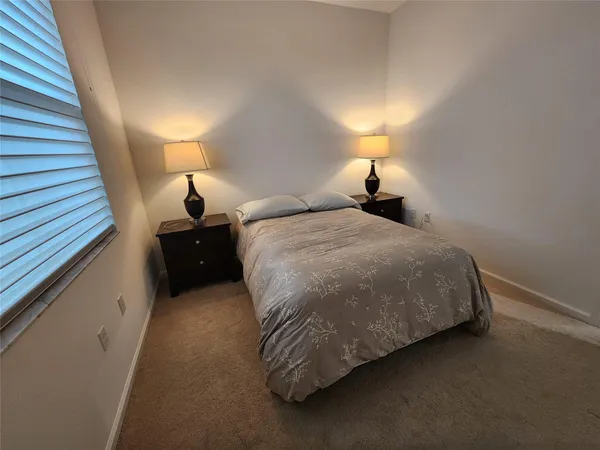 a bed sitting in a bedroom next to a lamp