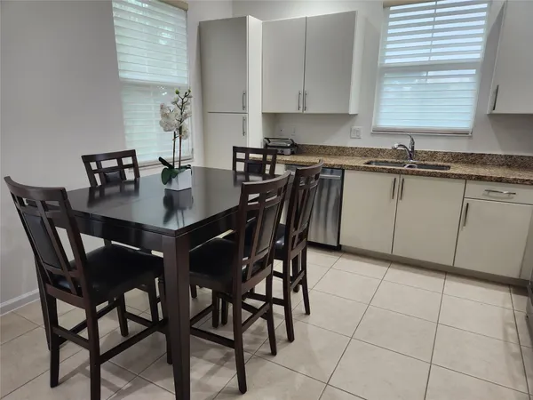 a kitchen with stainless steel appliances granite countertop a sink a stove a table and chairs