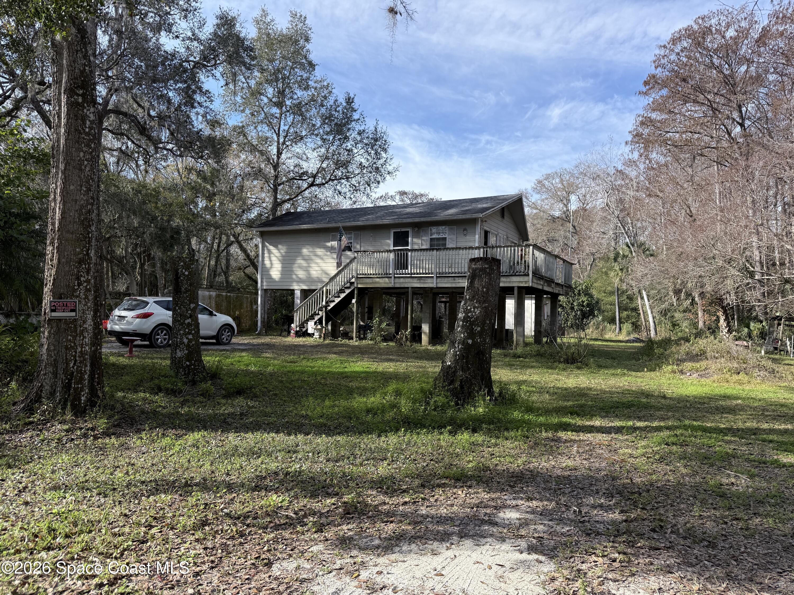 a view of a big house with a big yard and large trees