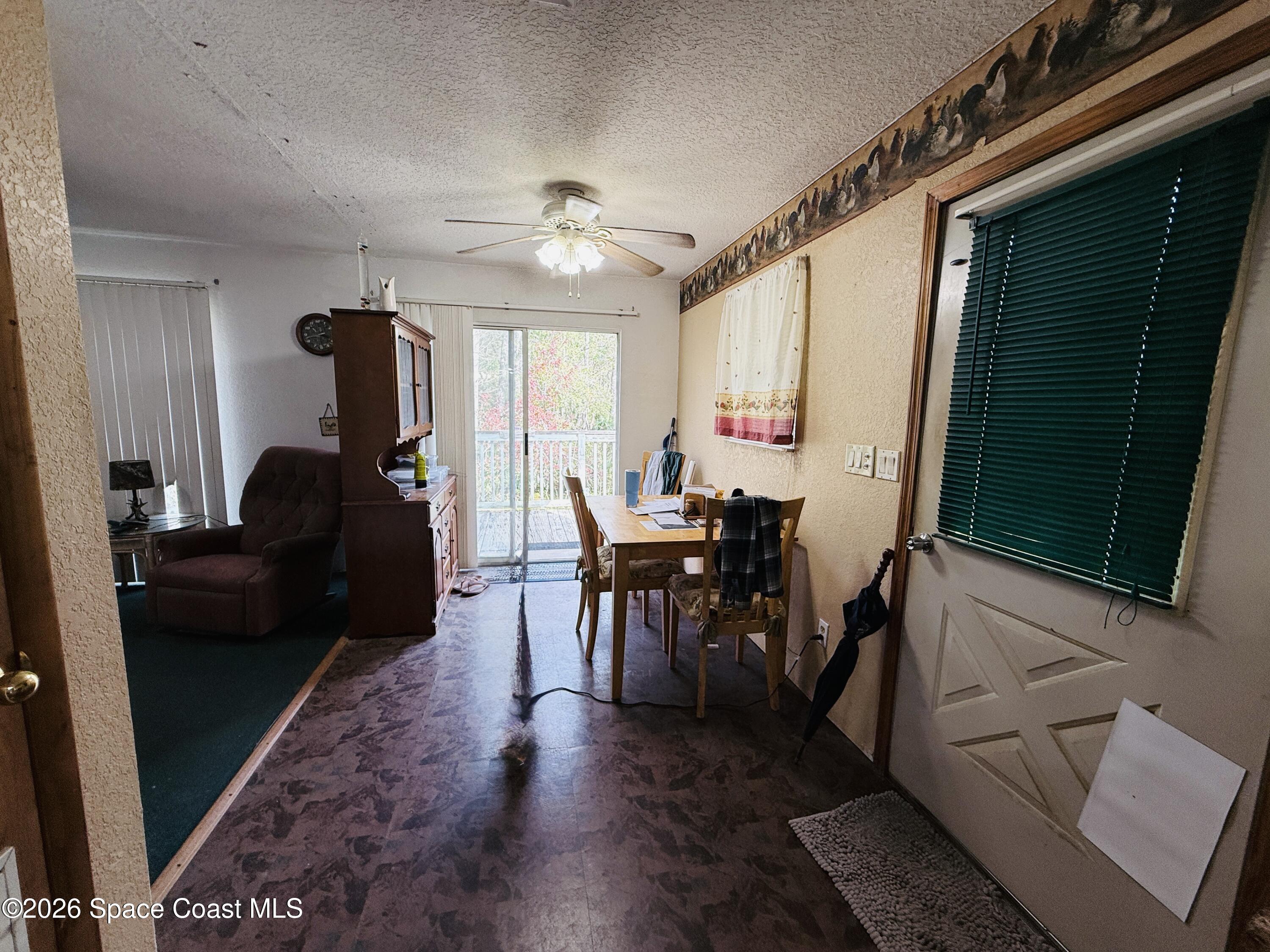4590 Hog Valley Road Mims, FL 32754 - Photo 11 of 29 a living room with furniture a window and a chandelier