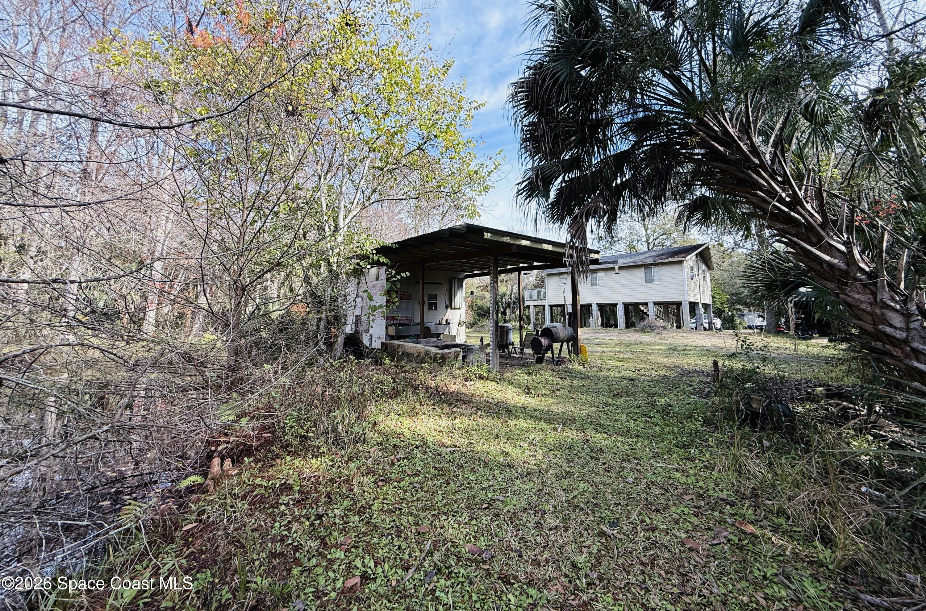 4590 Hog Valley Road Mims, FL 32754 - Photo 27 of 29 a view of a big yard with table and chairs under an umbrella
