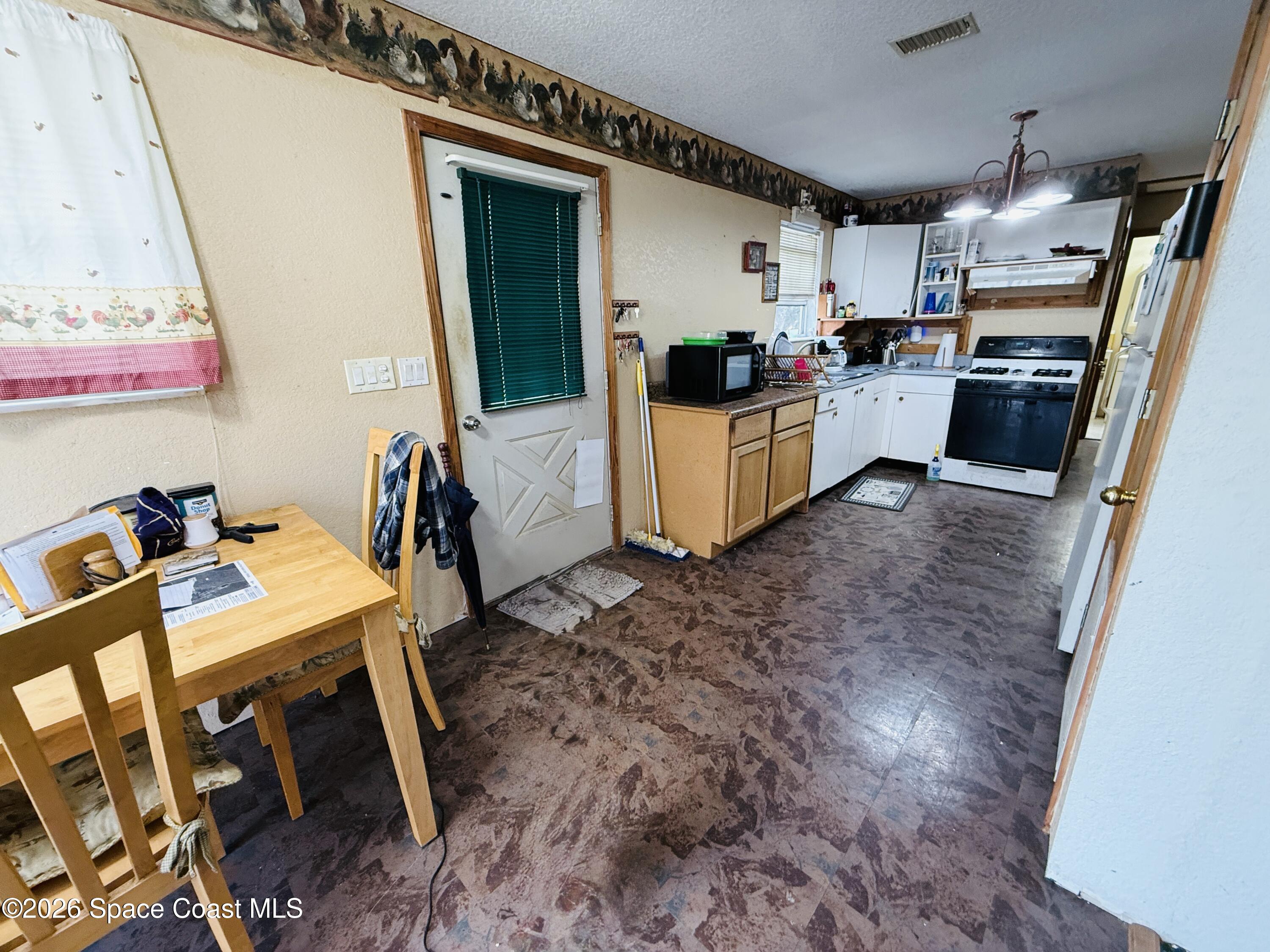 4590 Hog Valley Road Mims, FL 32754 - Photo 9 of 29 a kitchen that has a lot of cabinets a sink and a stove in it