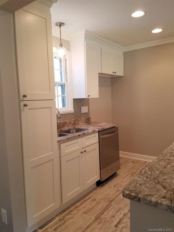 543 Scaleybark Road Charlotte, NC 28209 - Photo 8 of 24 a kitchen with a sink a refrigerator a stove and white cabinets
