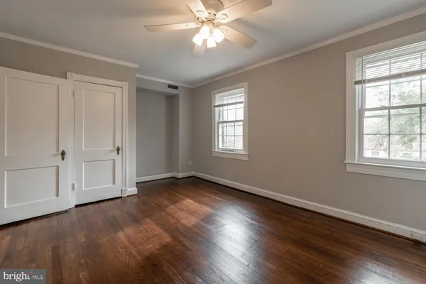 a view of an empty room with wooden floor and window