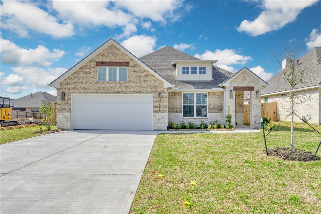 a view of yellow house with a big yard and large trees
