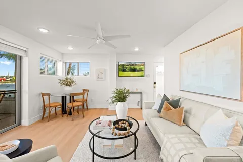 a living room with furniture and a dining table with bookshelf