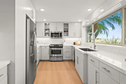 a kitchen with stainless steel appliances granite countertop a sink and a stove