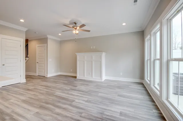 a view of an empty room with a window and wooden floor