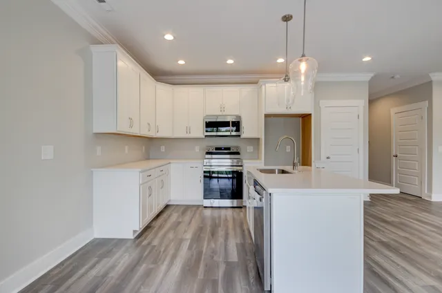 a kitchen with a sink a counter top space stainless steel appliances and cabinets